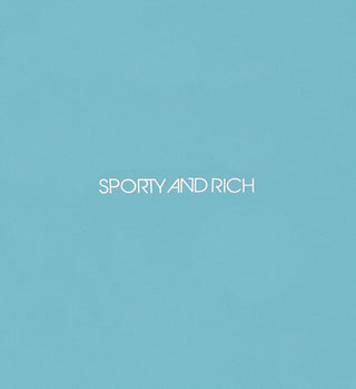 The Sports Bra N.03 - Stone Blue features a light blue background with “SPORTY AND RICH” in white, centered in a modern font—blending style, support, and comfort for your favorite workout routine.