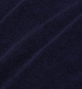 Close-up of the SR Tennis Terry Polo - Navy/White, crafted in Portugal from soft, textured 100% cotton terry fabric with visible diagonal folds.