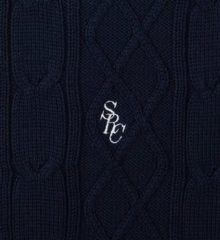 Close-up of the SRC Cableknit Vest in navy/white, made in Portugal from 100% cotton with white SPC embroidery at the center.