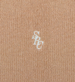 The SRC Cashmere Sweatpant - Camel features tan knit fabric with white embroidered “SRC” letters overlapping at the center, plus ribbed ankles and an elastic waistband for a cozy, cashmere-inspired feel.