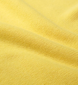 Close-up of the SRC Wool Crewneck in Daffodil, showing its textured yellow lambswool fabric with a visible weave and gentle folds. Made in Italy.