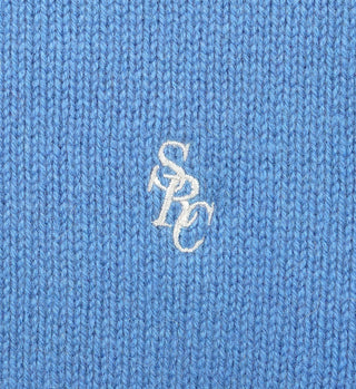 Close-up of the SRC Wool Crewneck - Ocean, featuring soft blue lambswool knit with white embroidered SPC lettering at the center. Made in Italy.