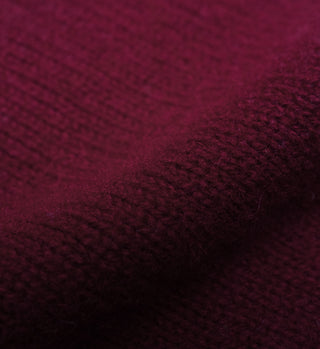 Close-up of the SRC Turtleneck - Merlot showcases its maroon lambswool knit fabric with a visible textured and slightly fuzzy surface.